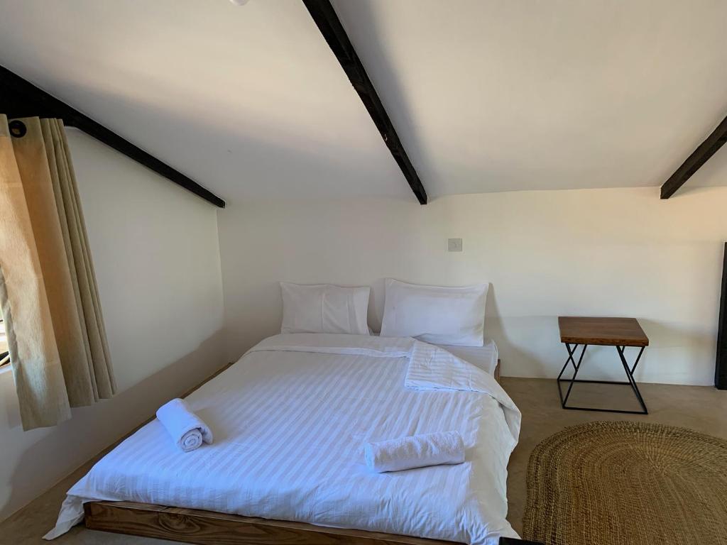 a bedroom with a white bed in a attic at Lilac Hideaway in Karatu