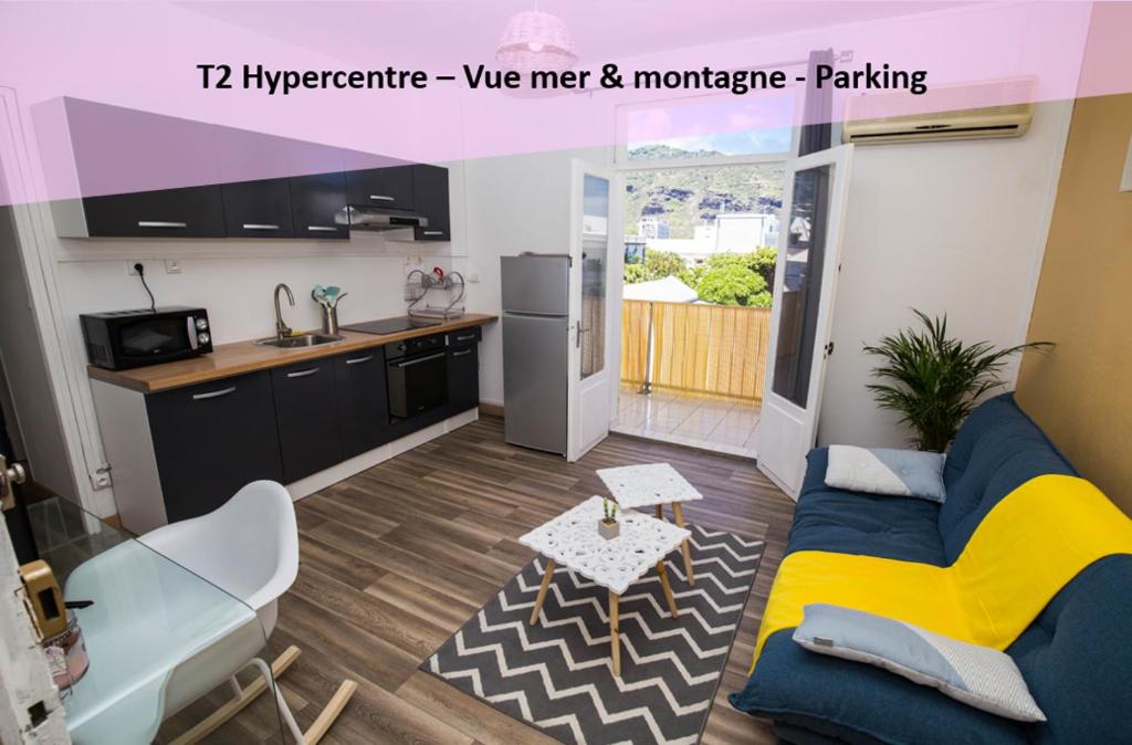 ein Wohnzimmer mit einem blauen Sofa und einer Küche in der Unterkunft T2 40m² Hypercentre in Saint-Denis