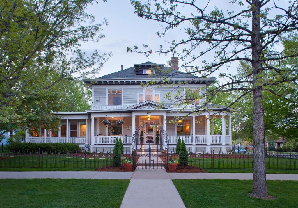 una casa blanca con una puerta delante de ella en Edwards House, en Fort Collins