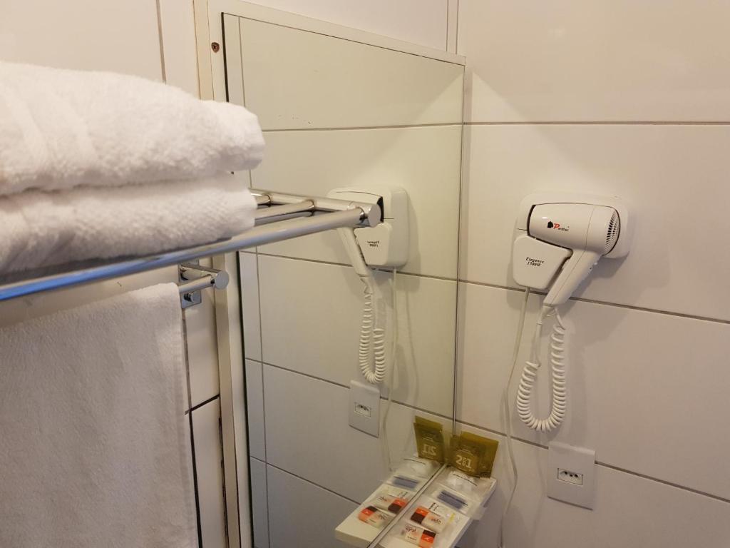 a bathroom with a phone hanging on the wall at Tulipa Hotel in Torres