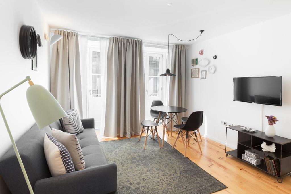 ein Wohnzimmer mit einem Sofa und einem Tisch in der Unterkunft Porto Center Apartments in Porto
