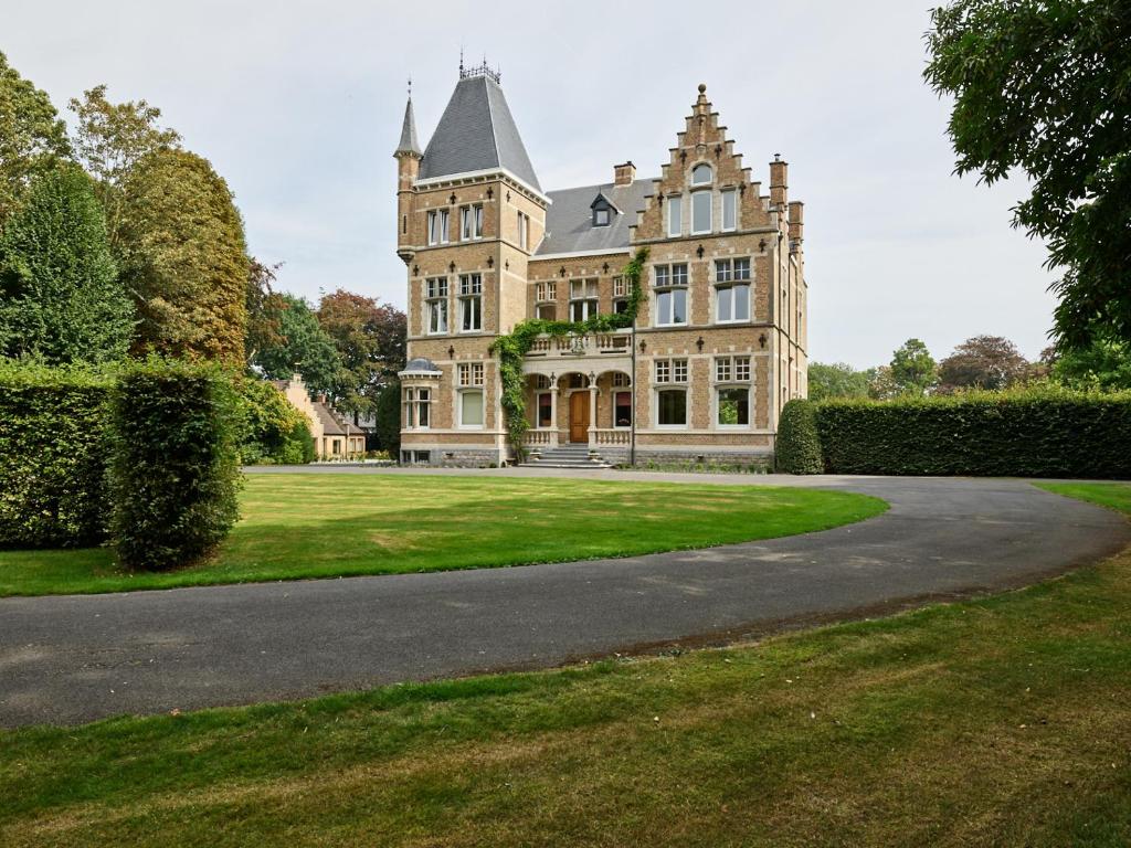 a large house with a driveway in front of it at Boutique Hotel Ter Wallen in Izegem