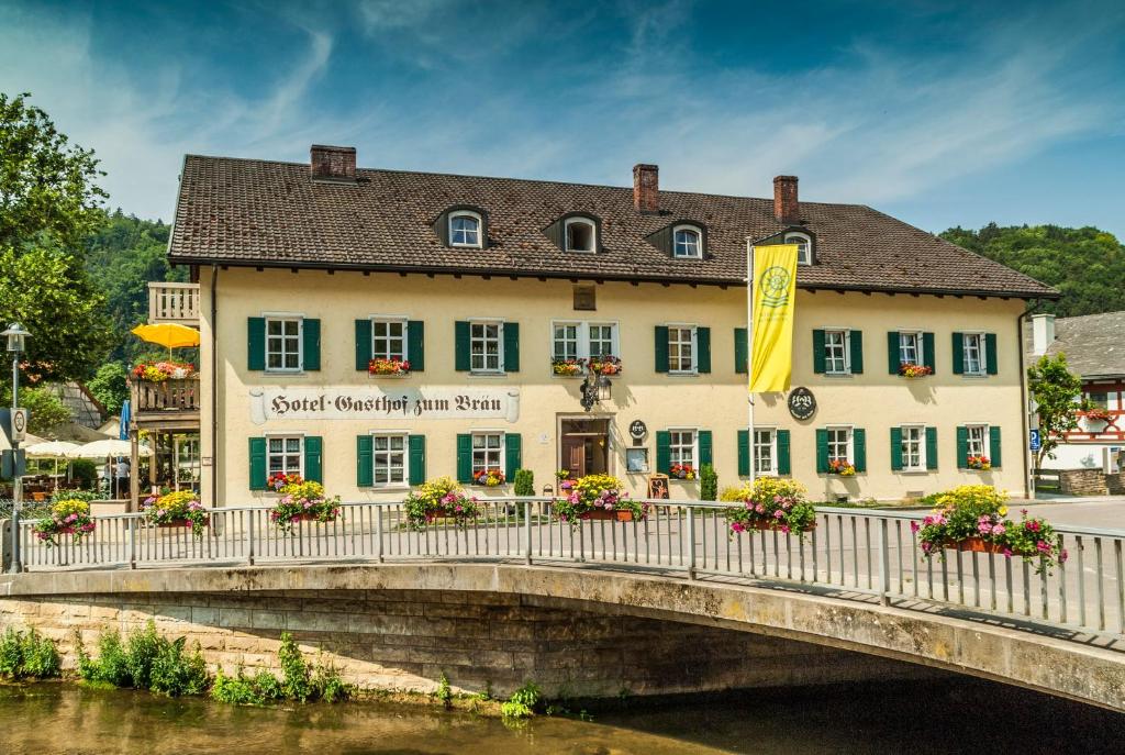 ein Gebäude auf einer Brücke über einen Fluss in der Unterkunft Hotel zum Bräu in Kinding