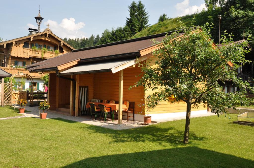 a wooden cabin with a table and chairs in a yard at Ferienhaus Hofwimmer in Kirchberg in Tirol