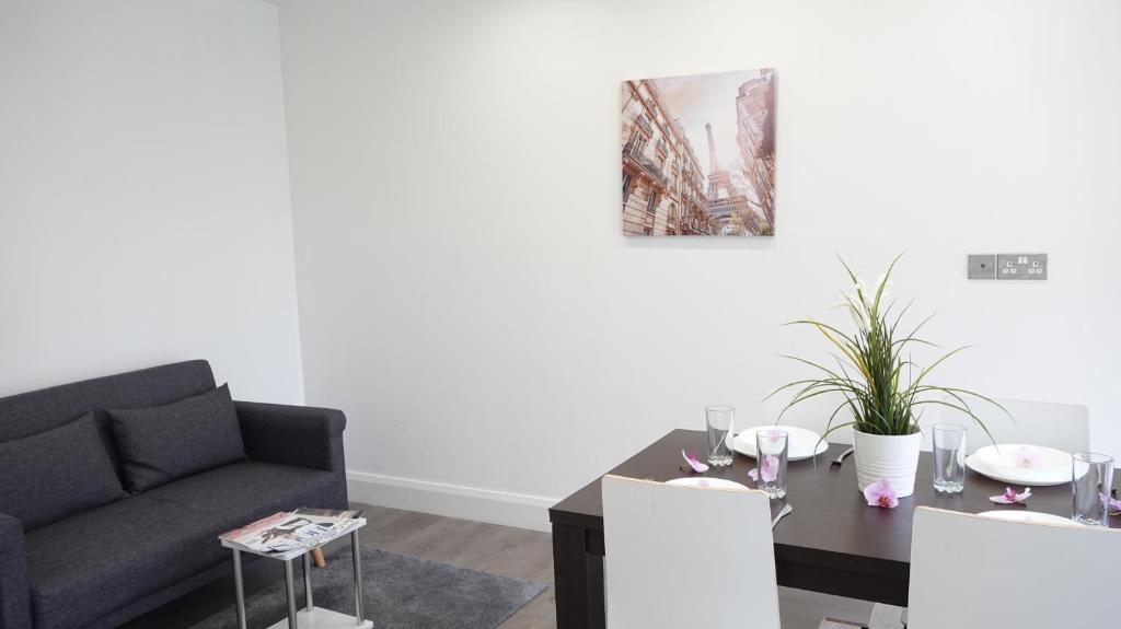 a living room with a couch and a table at The Hatton Rooms in New Bedfont