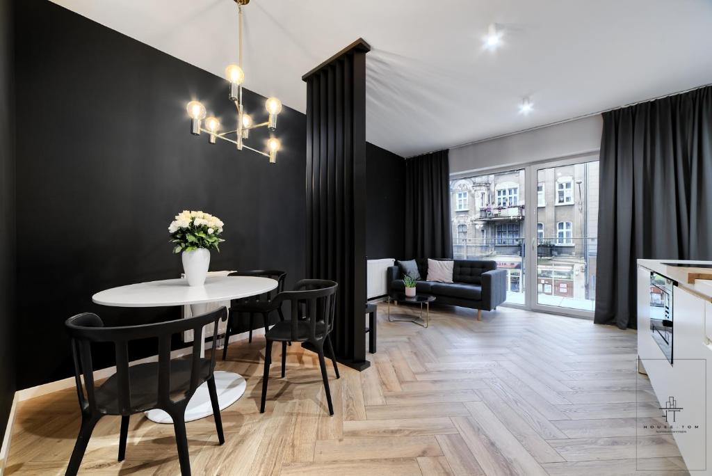 Un comedor y una sala de estar con mesa y sillas. en Apartament Business, en Poznan