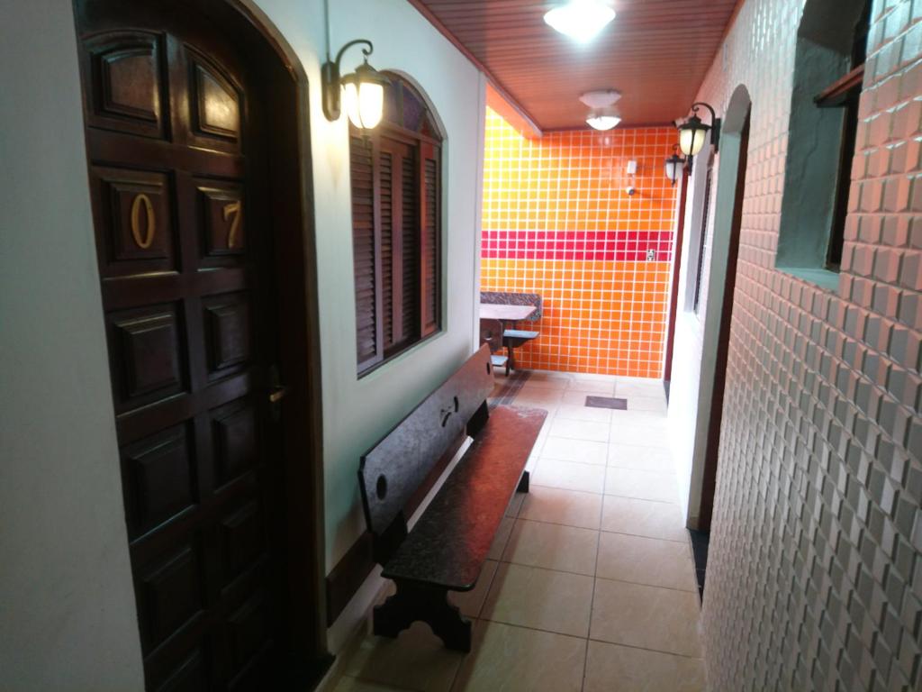 a hallway with a bench and a window in a room at Pousada Fonseca in Itanhaém