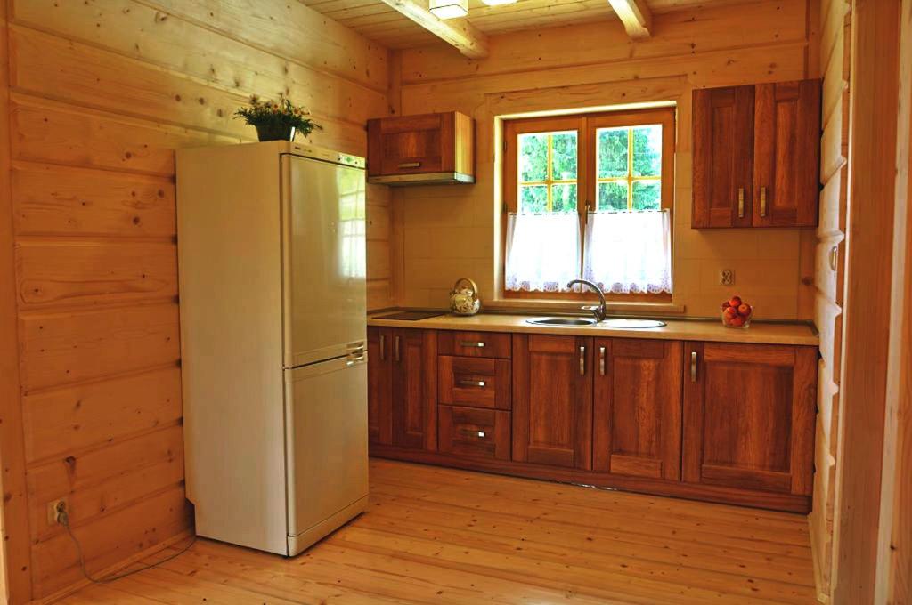 a kitchen with a refrigerator and a window at Domek na Kamieńcu in Witów