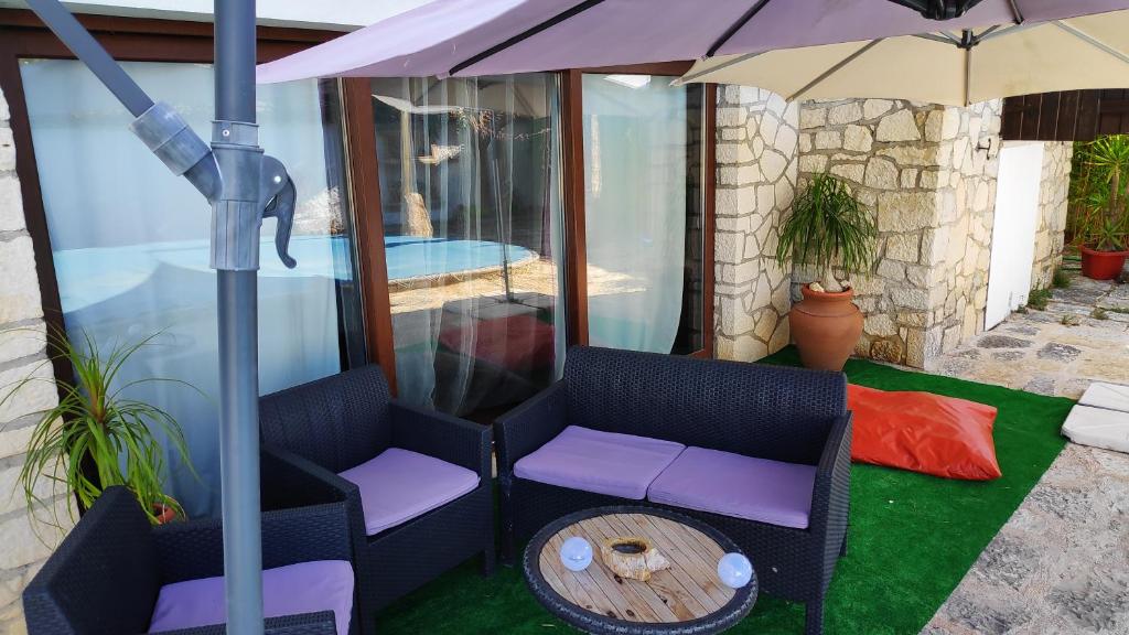 - une terrasse avec 2 chaises, un parasol et une table dans l'établissement Louro's Villa - 12130AL, à Cantanhede