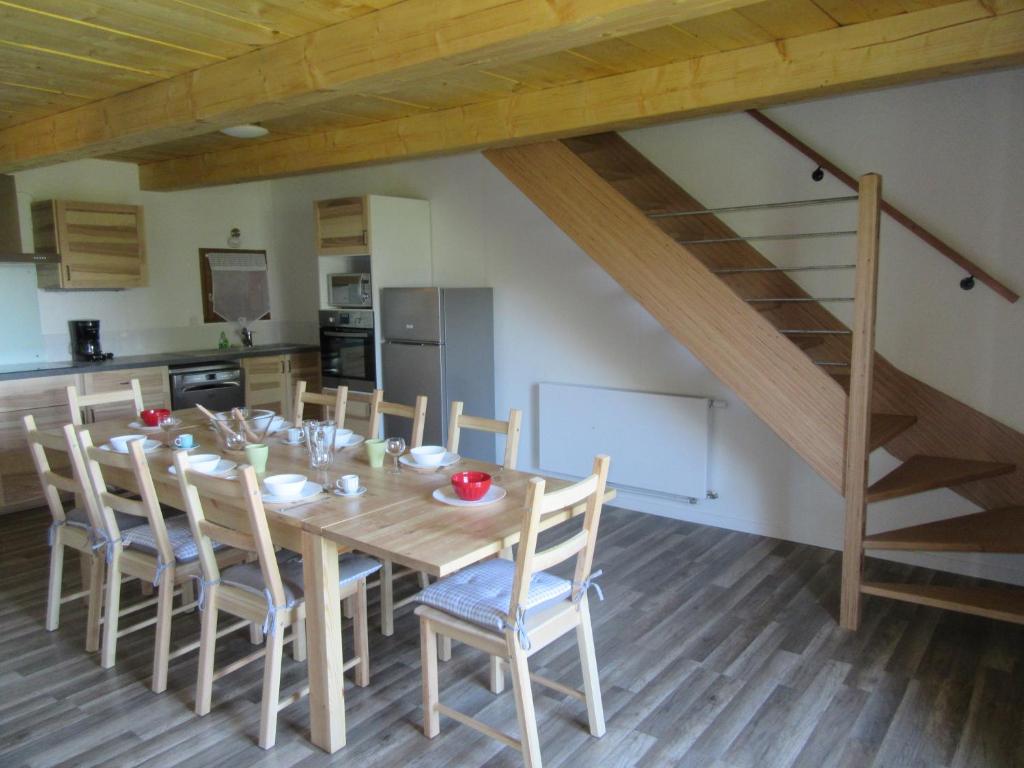 a kitchen and dining room with a table and a staircase at Gîte Potimarron in Ancelle