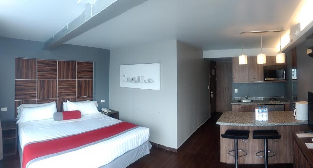 a hotel room with a bed and a kitchen at Hotel Block Suites in Mexico City