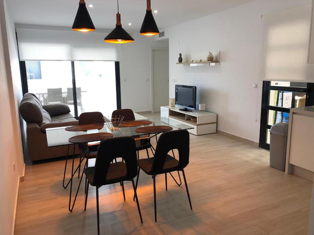 una cucina e un soggiorno con tavolo e sedie di Bel appartement à moins d 1km du Golf Villamartin a Orihuela