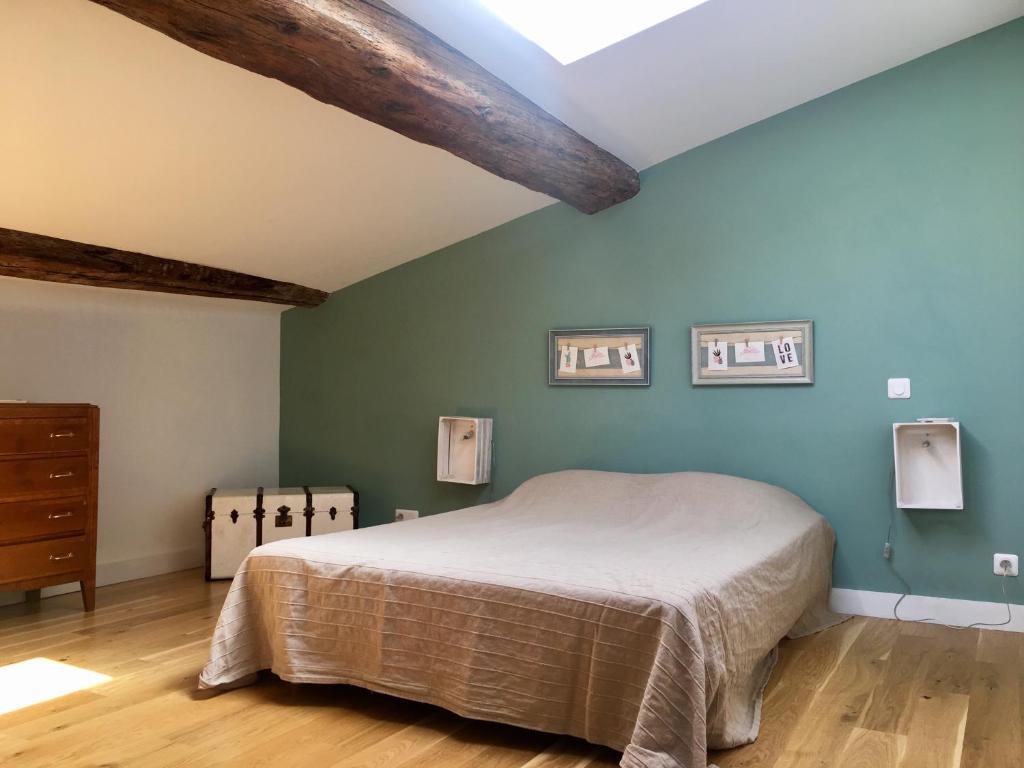 - une chambre avec un lit et un mur bleu dans l'établissement LOFT COCON EN PLEIN CENTRE DE SETE, à Sète