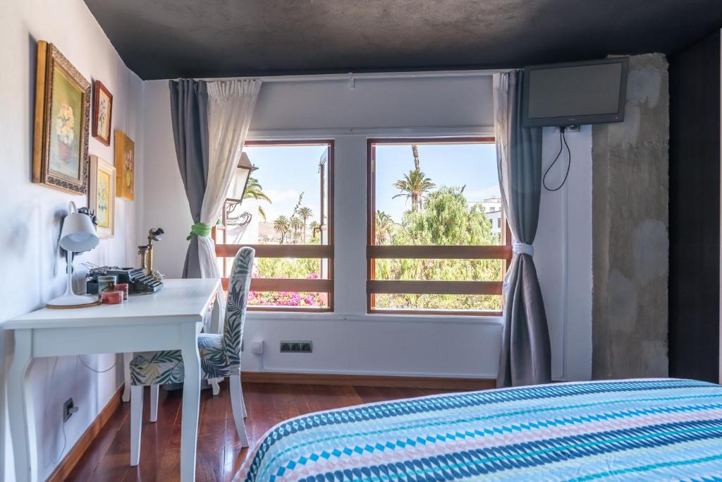 テルデにあるLoft La Fuenteのベッドルーム1室(ベッド1台、デスク、窓付)