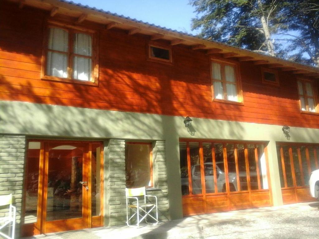 a wooden house with glass doors and windows at La Cabaña de Juan in Villa Traful