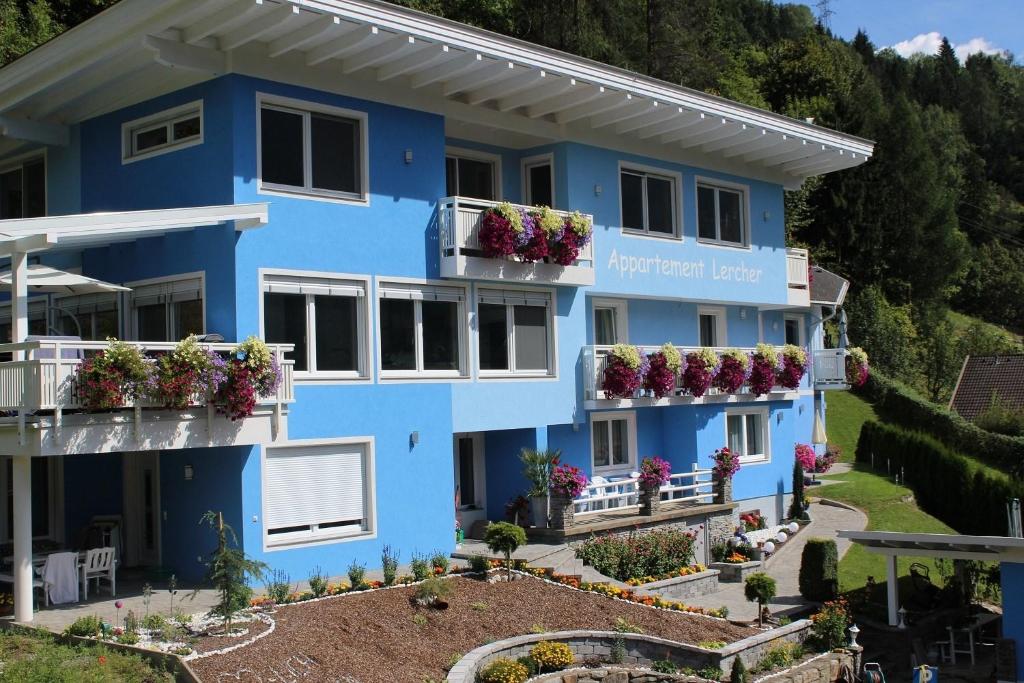 a blue building with flowers on the balconies at Flattach Apartment 1 in Ausserfragant