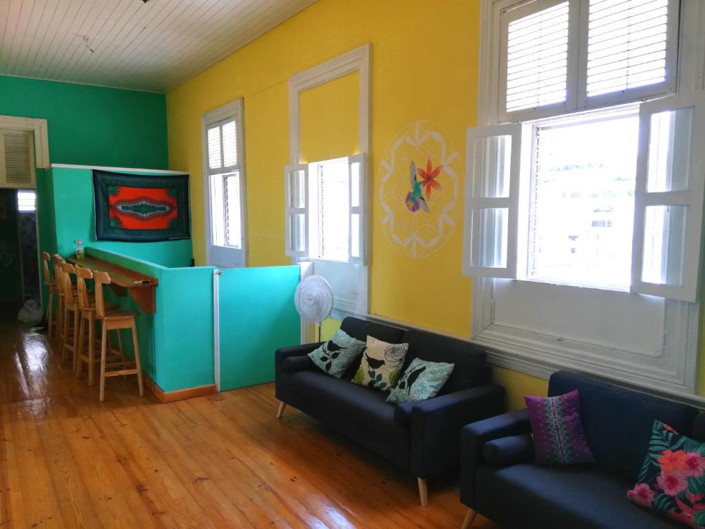 a living room with two couches and two windows at Park Hostel in Port-au-Prince