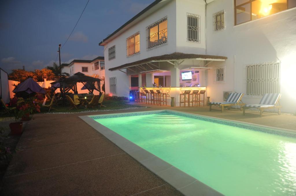 une maison avec une piscine en face d'une maison dans l'établissement Residence Helios, à Abidjan