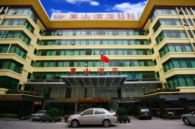 a large building with cars parked in front of it at Guangzhou Junshan Hotel - Shuttle bus for Canton Fair in Guangzhou