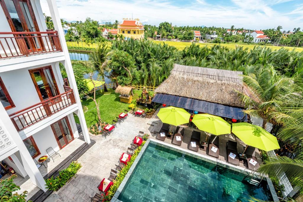 uma vista aérea de um hotel com uma piscina e guarda-sóis em Crony Villa - STAY 24H em Hoi An