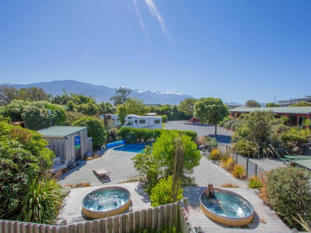 
a patio with a pool and a tennis court at Alpine-Pacific Holiday Park in Kaikoura
