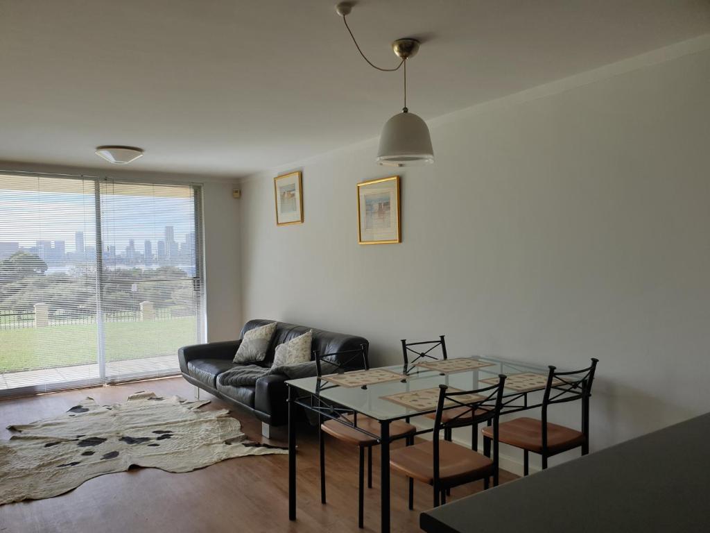 uma sala de estar com uma mesa e um sofá em Apartment with a View em Perth