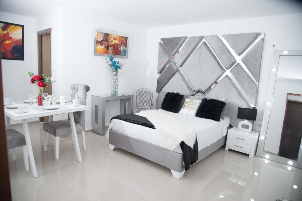 a bedroom with a bed and a table and a desk at Hotel Platinum Barranquilla in Barranquilla