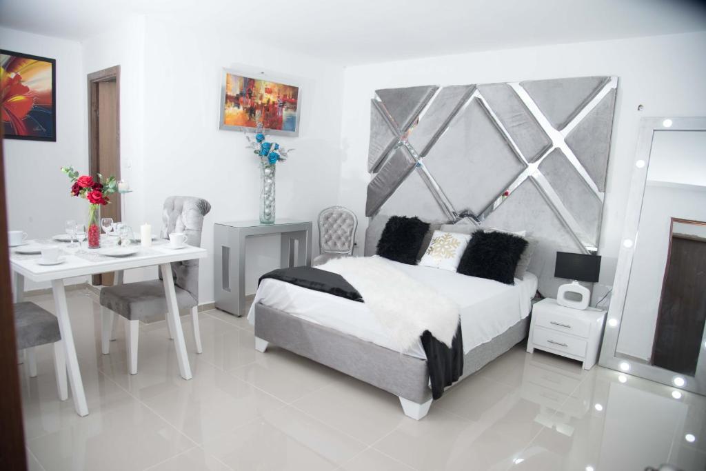 ein Schlafzimmer mit einem Bett, einem Tisch und einem Schreibtisch in der Unterkunft Hotel Platinum Barranquilla in Barranquilla