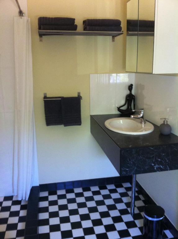 a bathroom with a sink and a checkered floor at Lotte's Cottage in Broken Hill