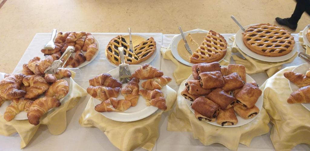 a table topped with different types of pastries and waffles at Hotel Corallo in Francavilla al Mare
