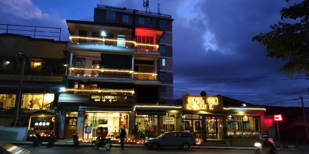 un bâtiment avec des panneaux de néon sur son côté dans l'établissement Kong Loon 1, à Taunggyi