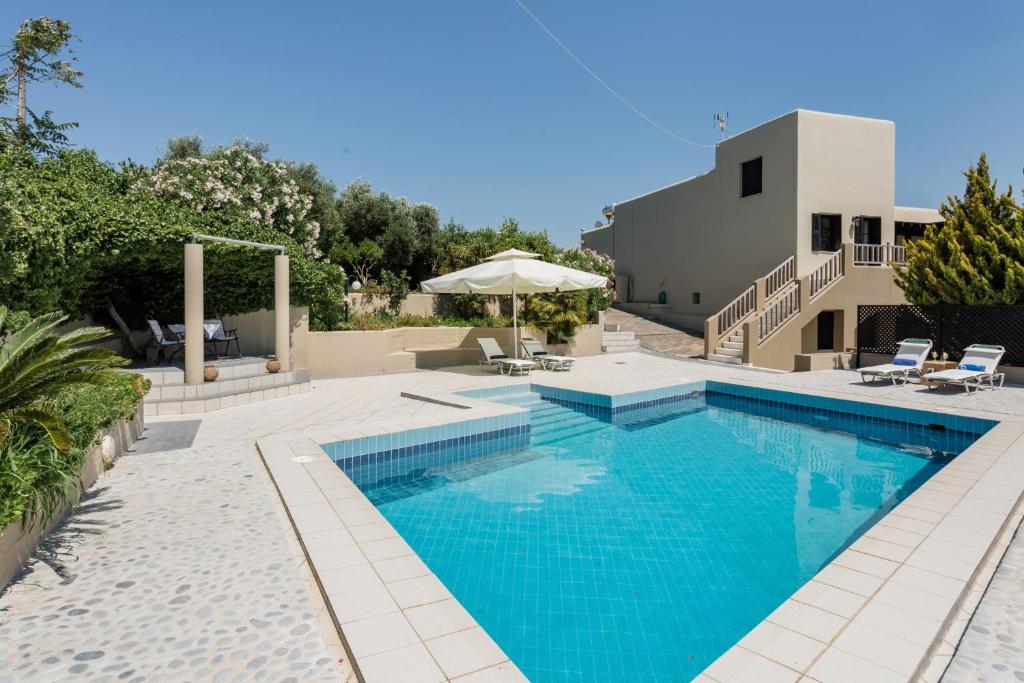 a swimming pool with blue water in a yard at Knossos Palace Secluded Villa in Skalánion