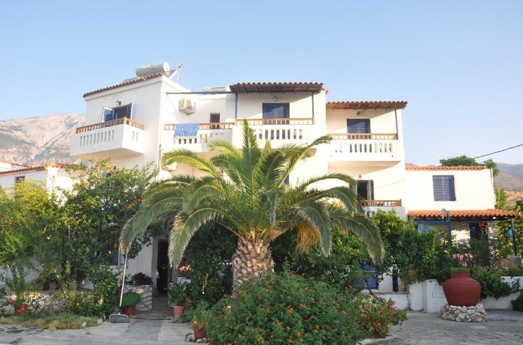 a building with a palm tree in front of it at Villa Maria in Marathokampos