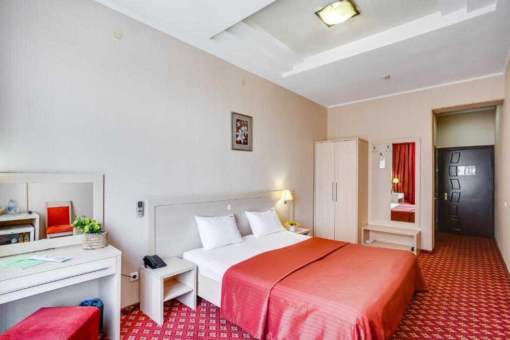 ロストフ・ナ・ドヌにあるPark City Hotelの大きなベッドとデスクが備わるホテルルームです。