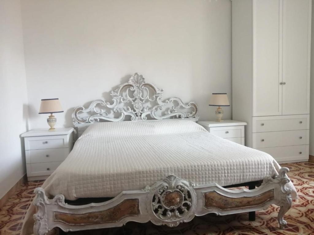 1 dormitorio con 1 cama blanca, 2 vestidores y 2 lámparas en Antico Borgo, en Bagnoregio