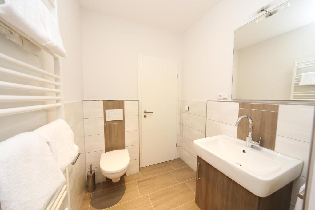La salle de bains blanche est pourvue d'un lavabo et de toilettes. dans l'établissement Villa Wasser, à Hörstel