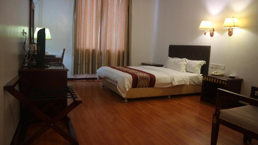 1 dormitorio con 1 cama y TV en Excelsior Resort, en Dili