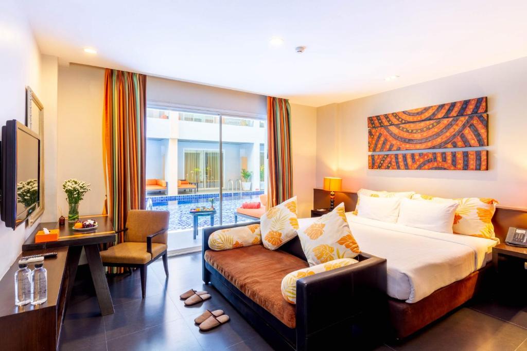チャアムにあるフラマエクスクルーシブ サンダラ ホアヒン アット チャアムビーチのベッドとソファ付きのホテルルーム