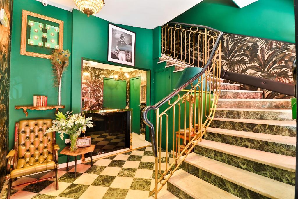eine Treppe in einem Zimmer mit grünen Wänden in der Unterkunft Hôtel Le G (ex Le Genève) in Nizza