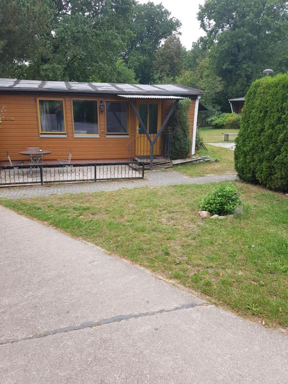 a small house with a porch and a yard at Ferienpark am Hellsee in Biesenthal