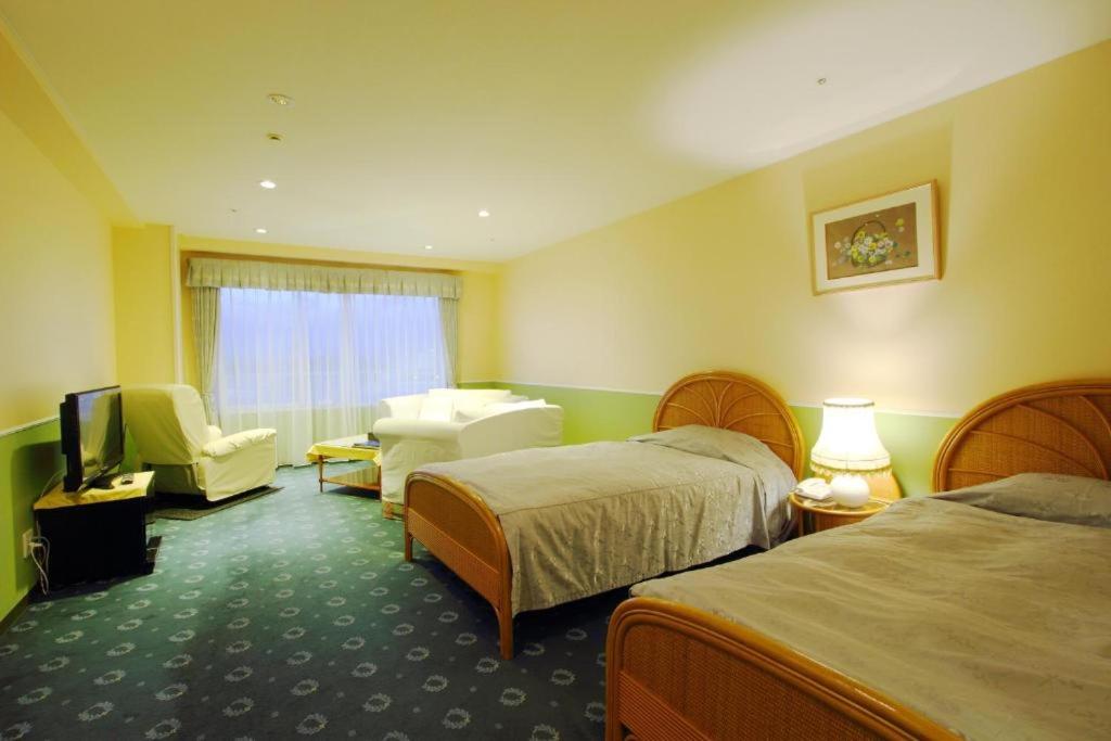 pokój hotelowy z 2 łóżkami i telewizorem w obiekcie Yanagiya w mieście Shirahama