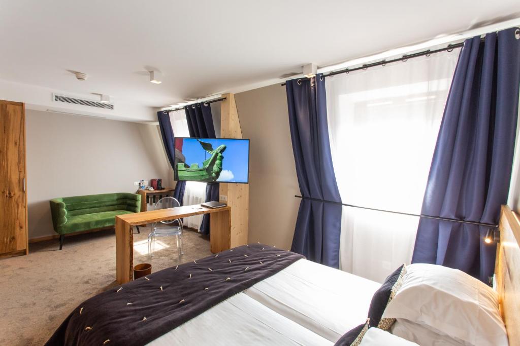 TV a/nebo společenská místnost v ubytování Hôtel Le Rapp