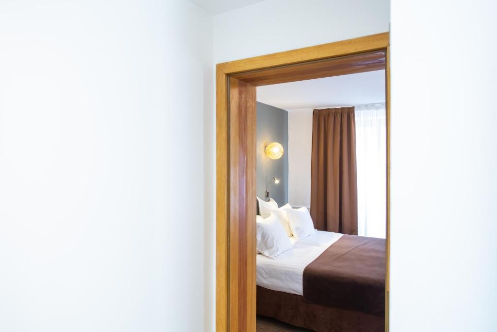 Postel nebo postele na pokoji v ubytování Hôtel Le Rapp