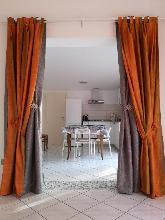 una camera con tende arancioni e grigie in cucina di Sul Confine a Cervia