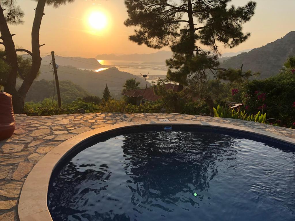 a swimming pool with a sunset in the background at Villa kaplumba in Dalyan