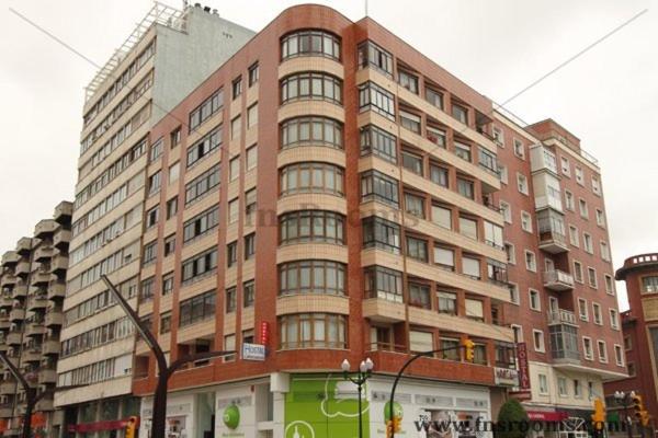 a large brick building on the corner of a street at Hostal Campoamor in Gijón