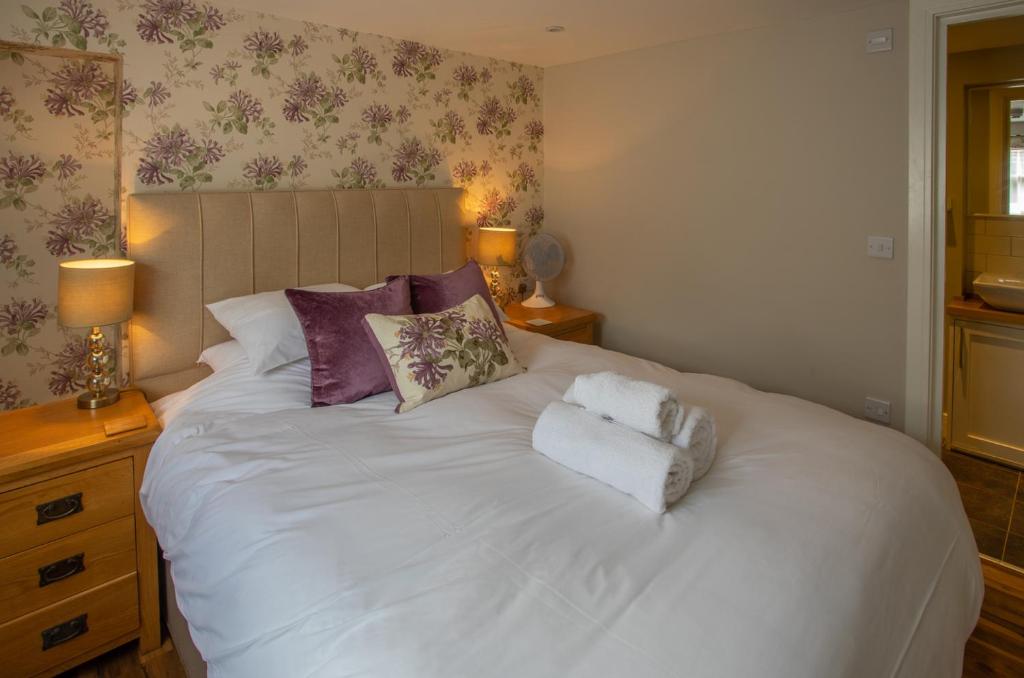 a bedroom with a white bed with two towels on it at The White Lion, Soberton in Soberton