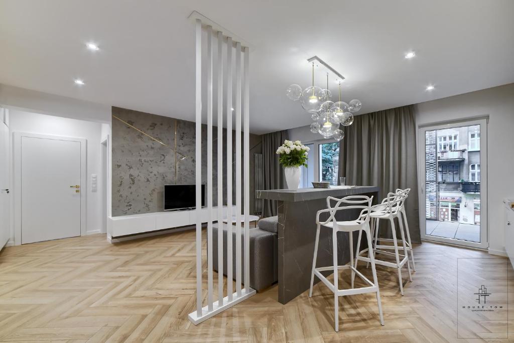 a kitchen and living room with a bar and stools at Apartament DeLux in Poznań