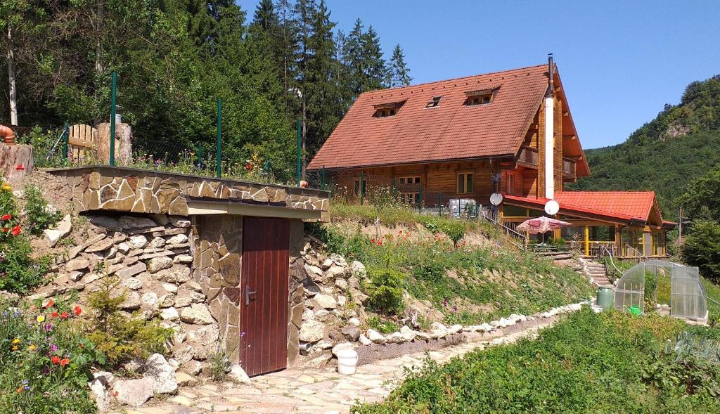 ein Haus auf einem Hügel mit einer Steinmauer in der Unterkunft Penzión Racibor in Oravský Podzámok