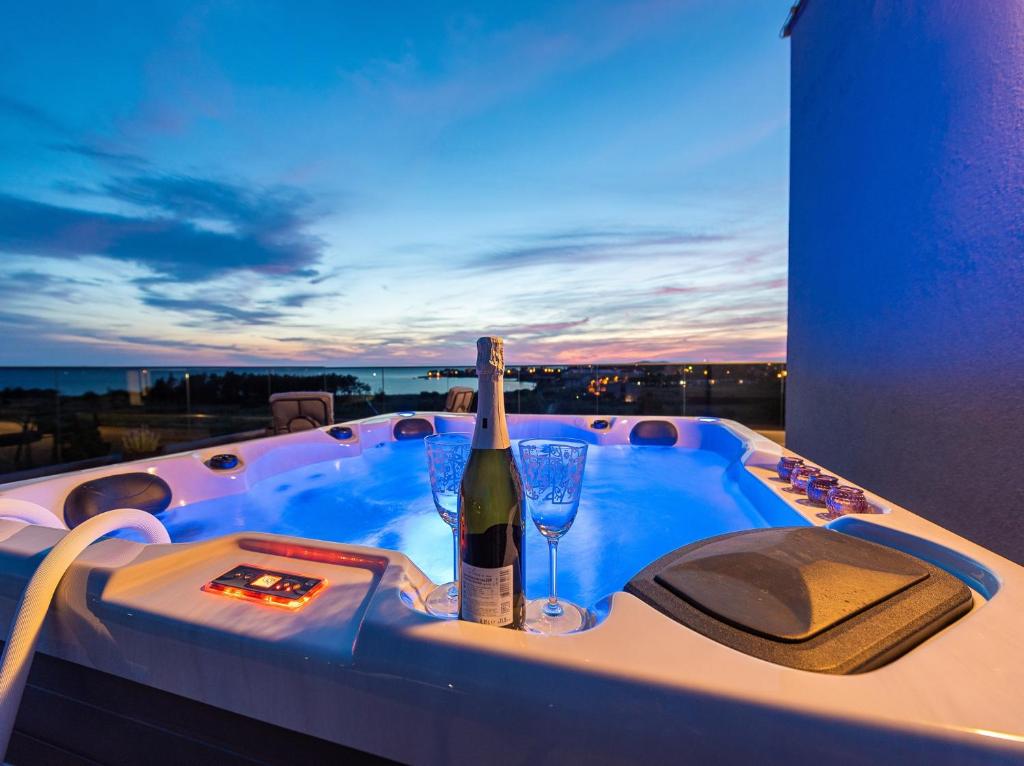 wanna z hydromasażem z butelką wina i kieliszkiem w obiekcie Villa Contessa w mieście Privlaka